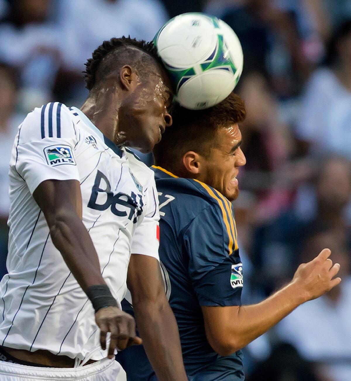 Vancouver's Gershon Koffe, left, and Galaxy midfielder Hector Jimenez battle for the ball during a game in August. Don't expect to see any major changes to the 2014 Major League Soccer schedule, a spokesman says.
