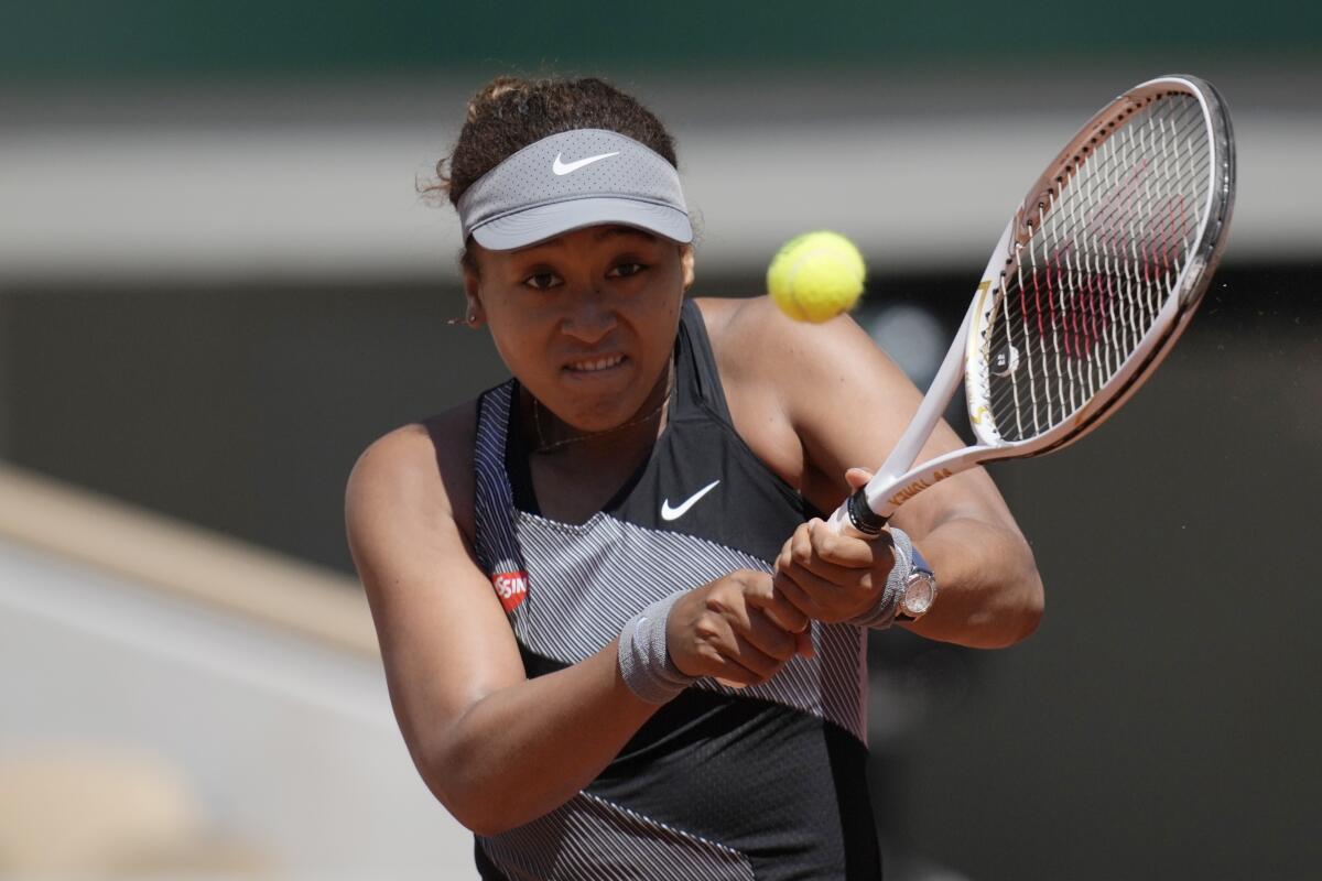 Naomi Osaka returns the ball.