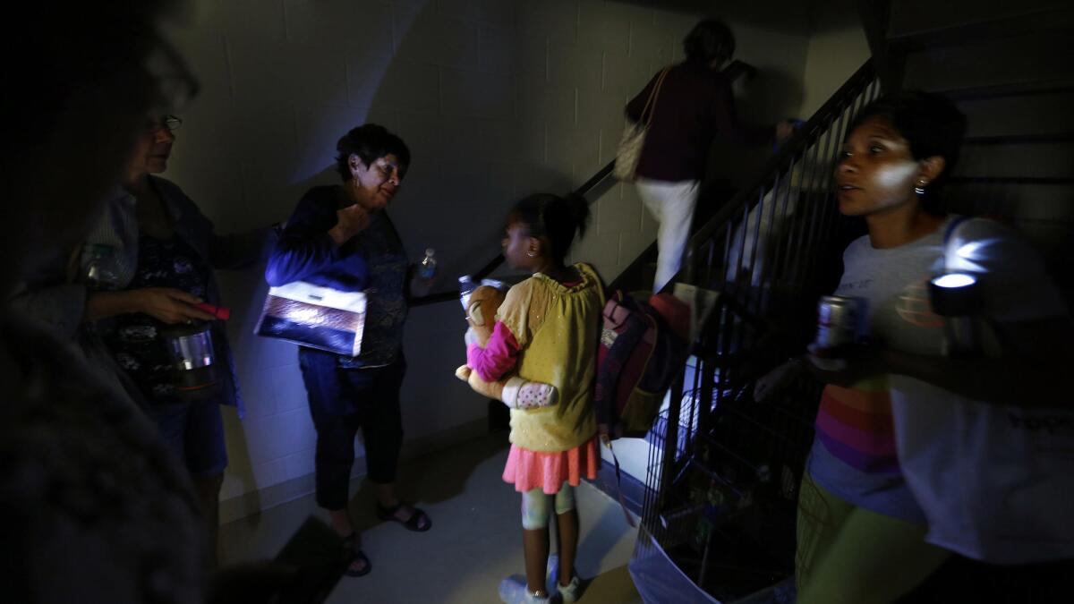 Hurricane Irma evacuees use flashlights at the Hampton Inn and Suites in Estero, Fla.