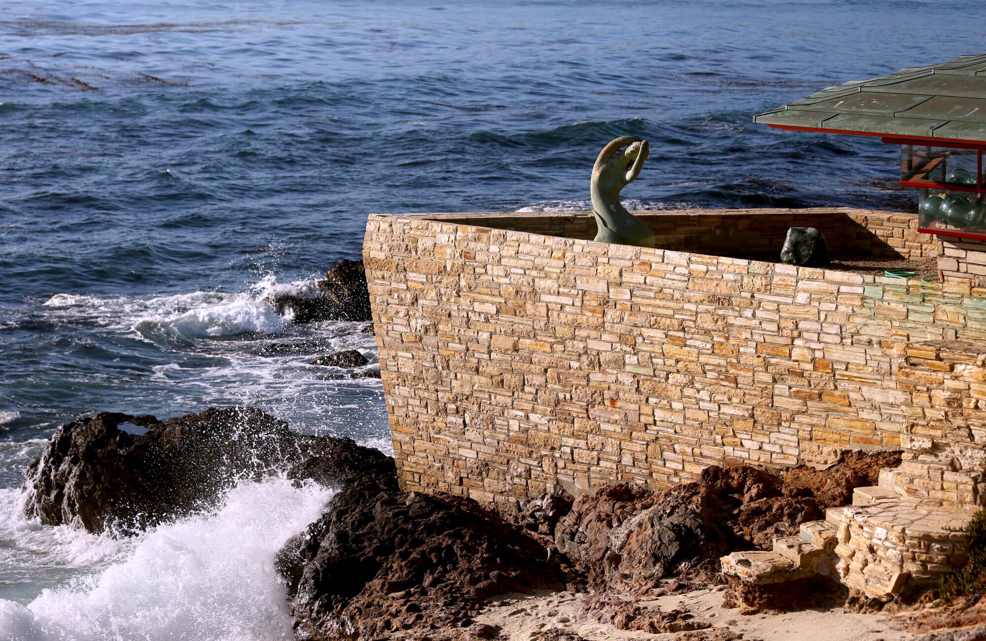 一座历史悠久的房屋的石墙像船头一样伸入海洋。 