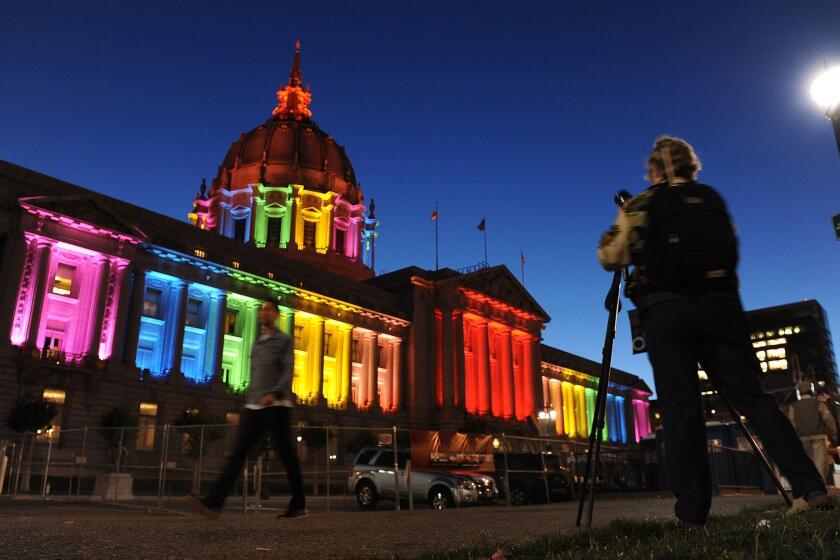 San Francisco City Hall is lit up in rainbow colors the night before the city's gay pride parade.