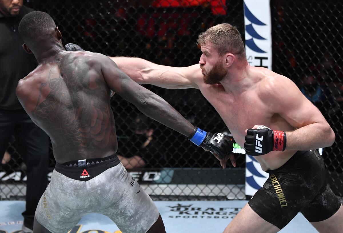 Jan Blachowicz, right, punches Israel Adesanya during their UFC light heavyweight championship fight Saturday.