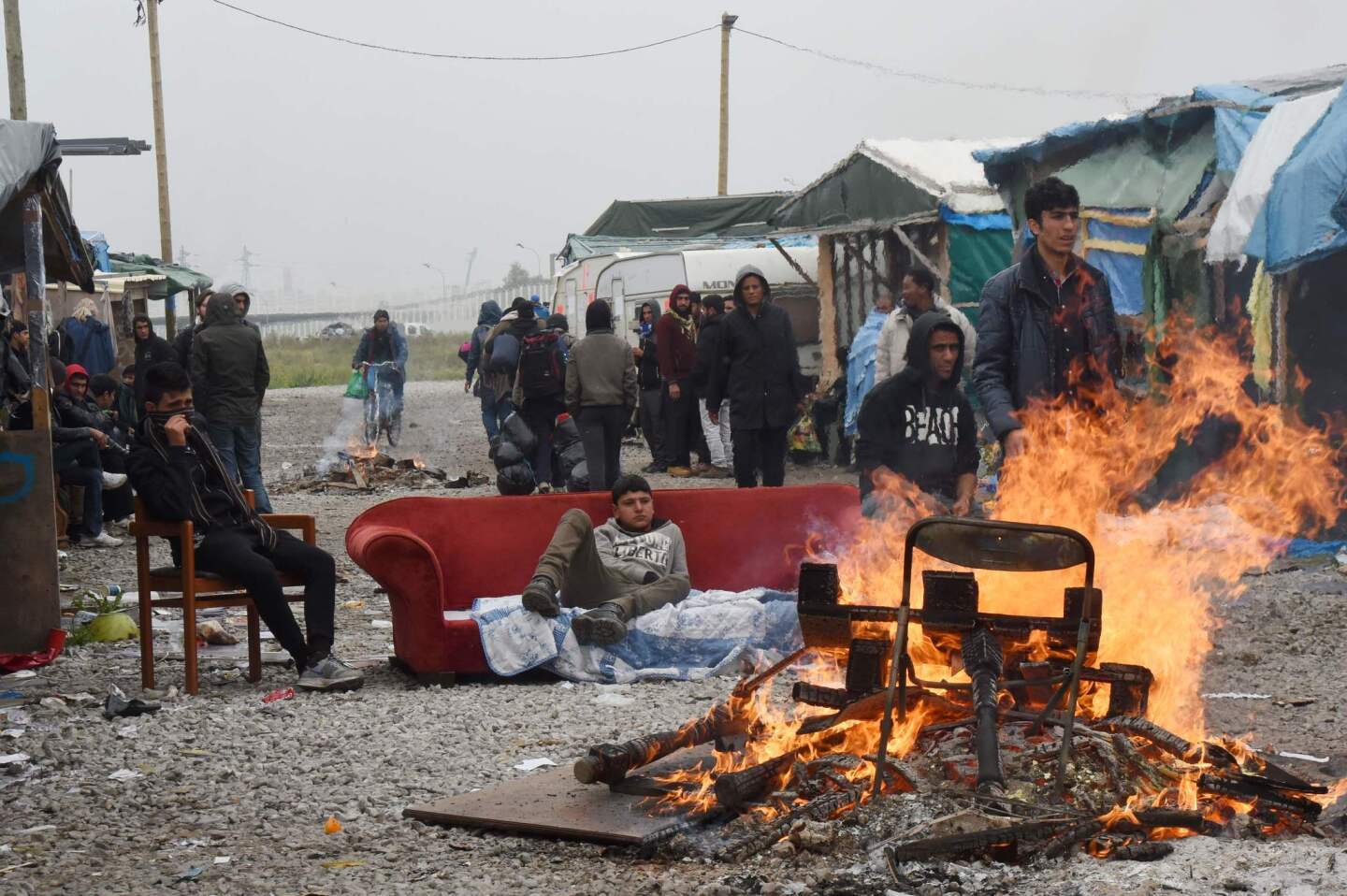 Migrants gather by their tents and a bonfire in a migrant camp known as "the Jungle," in Calais, France, before an operation to clear the camp of its estimated 6,000 to 8,000 occupants.