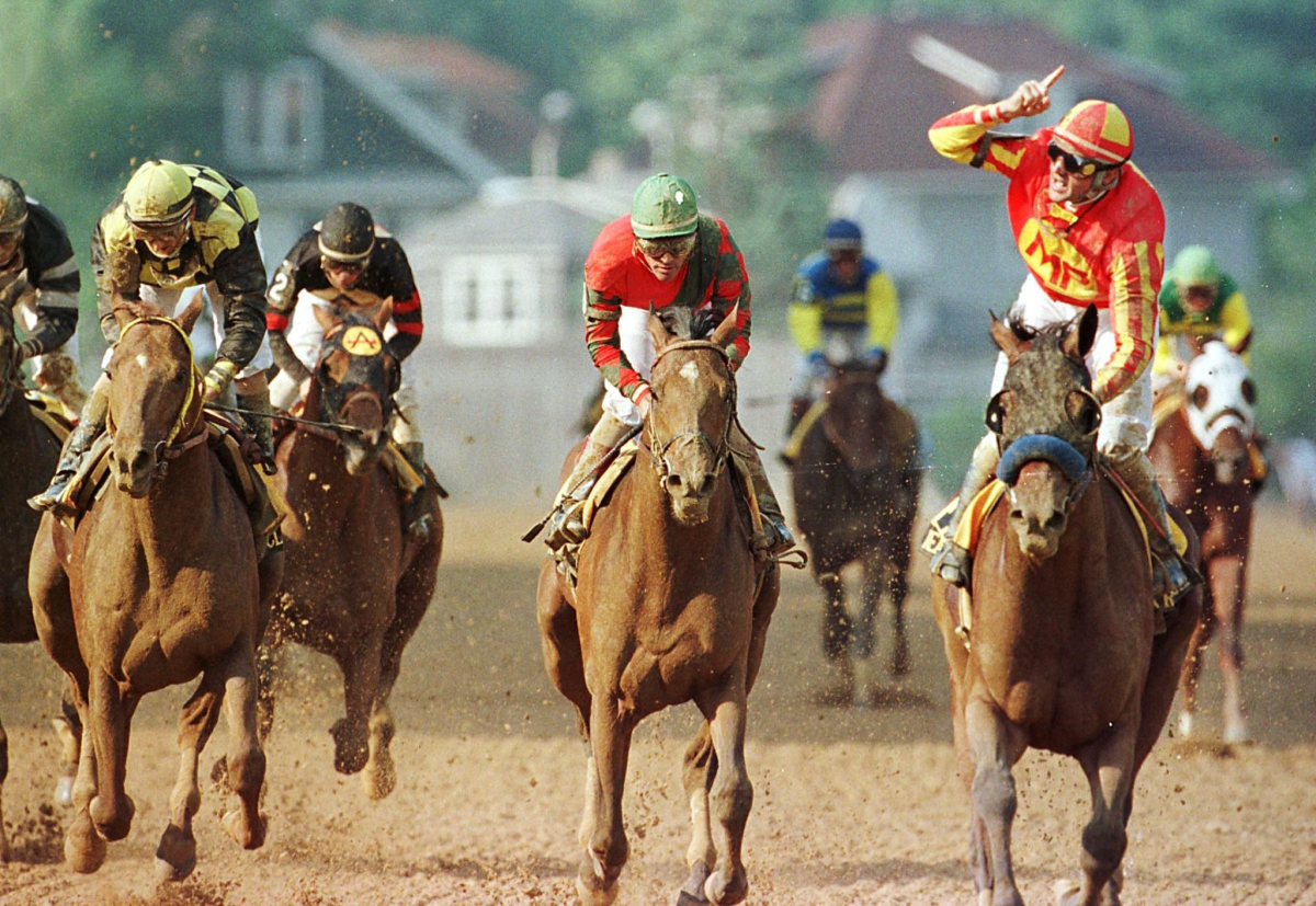 Jockey Kent Desormeaux, right, celebrates as he rides Real Quiet across the finish line to win.