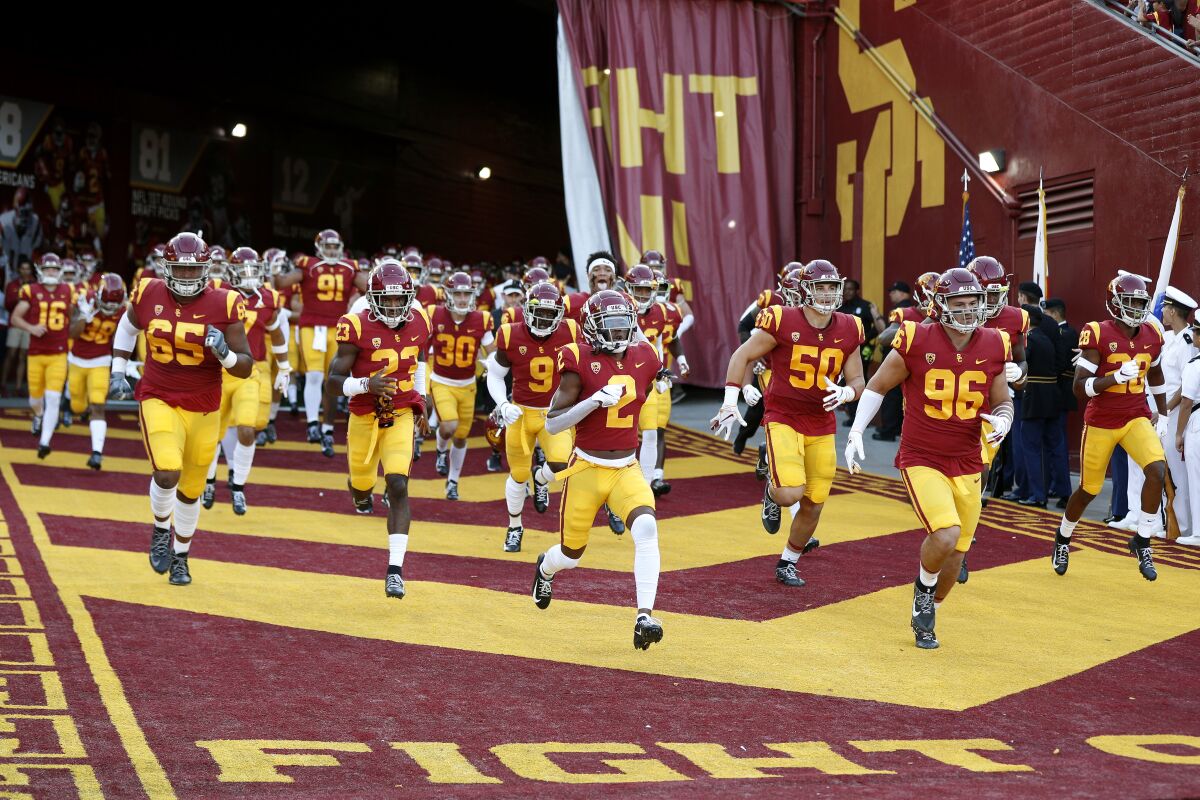 USC players run onto the field before their game against Utah at the Coliseum on Sept. 20.