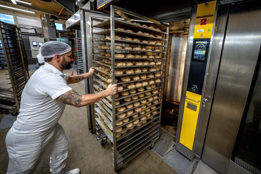 ADDING FULL NAME OF BUSINESS An employee pushes bread rolls into one of the gas heated ovens in the producing facility in Cafe Ernst in Neu Isenburg, Germany, Monday, Sept. 19, 2022. Andreas Schmitt, head of the local bakers' guild, said some small bakeries are contemplating giving up due to the energy crisis. (AP Photo/Michael Probst)