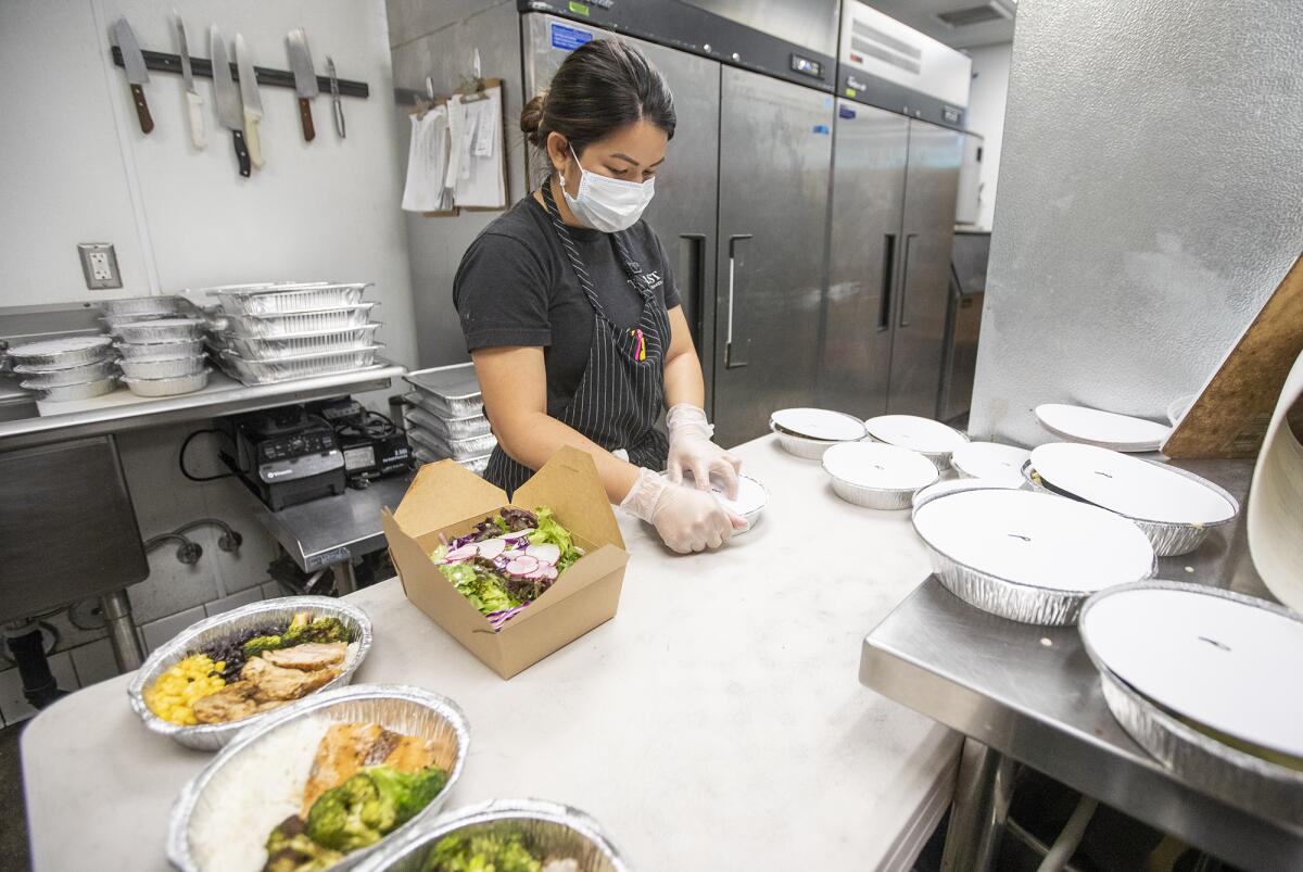Holley Sao, kitchen manager for Toast Kitchen + Bakery, prepares meals for Delivering with Dignity on Wednesday.