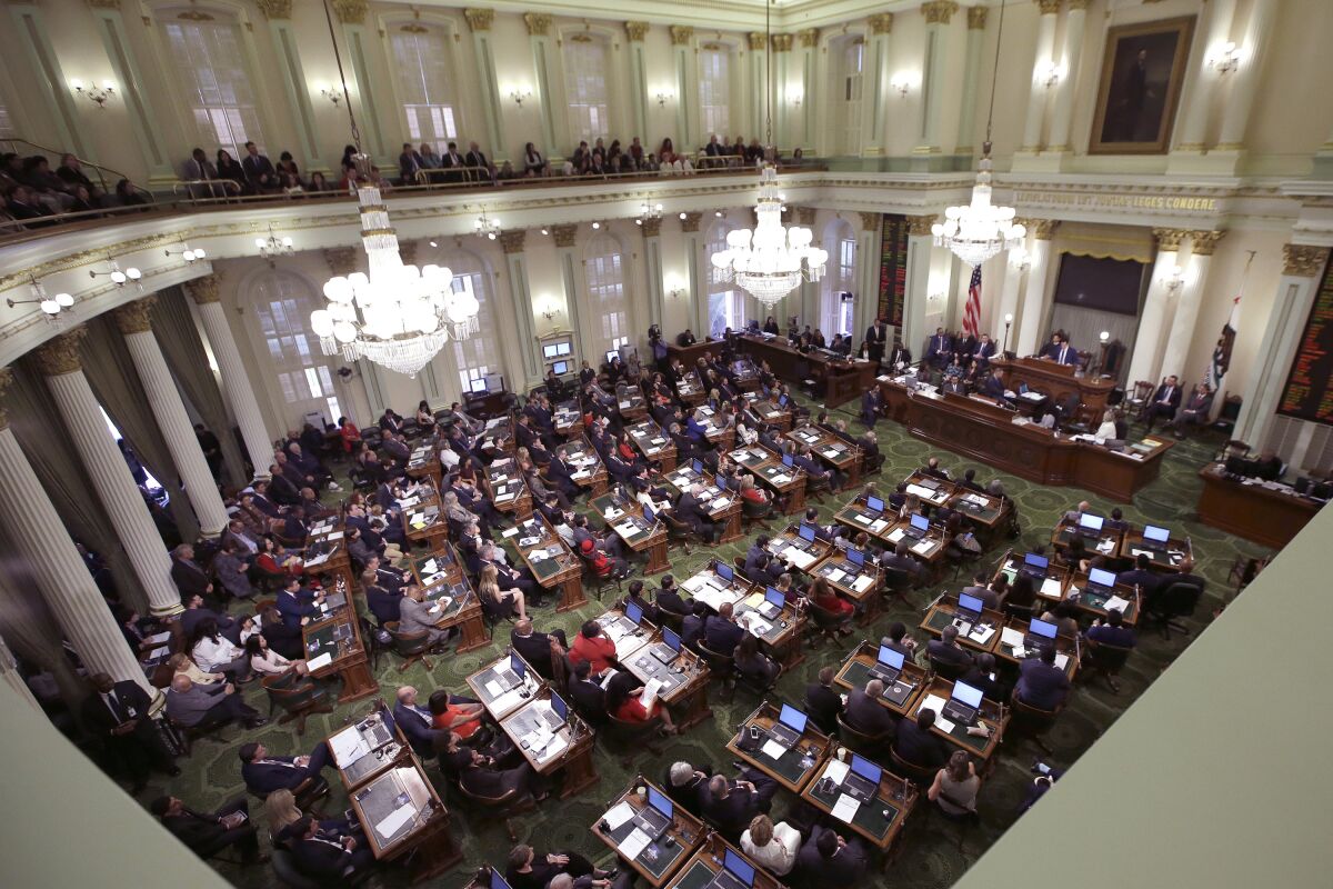 FILE - Members of the state Assembly listen to an address by Assembly Speaker Anthony Rendon, D-Paramount, at the Capitol in Sacramento, Calif., Monday, Dec. 5, 2016. On Monday, Aug. 3, 2020, the California Assembly voted 48-10 to approve a new rule allowing lawmakers at high risk for the coronavirus to vote on bills without being present in the chamber. The vote comes despite an opinion from the Legislative Counsel Bureau saying it likely violates the state Constitution. (AP Photo/Rich Pedroncelli, File)