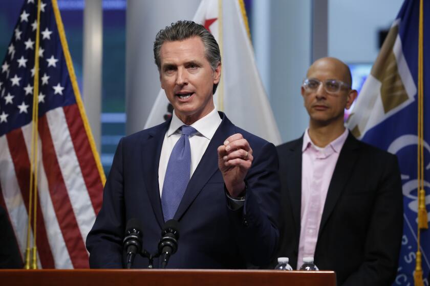 FILE - In this March 17, 2020 file photo, California Gov. Gavin Newsom gives an update to the state's response to the coronavirus at the Governor's Office of Emergency Services in Rancho Cordova Calif. On Tuesday, March 17, when announcing that he had put the National Guard on alert, Newsom said martial law could be used "if we feel the necessity." Martial law is when civil laws are suspended and a military force is in charge. Newsom has asked people to not gather in large numbers and generally stay inside during the coronavirus outbreak, and so far most are obeying. (AP Photo/Rich Pedroncelli, Pool)