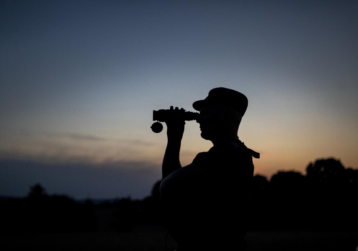 Border guard looking through binoculars