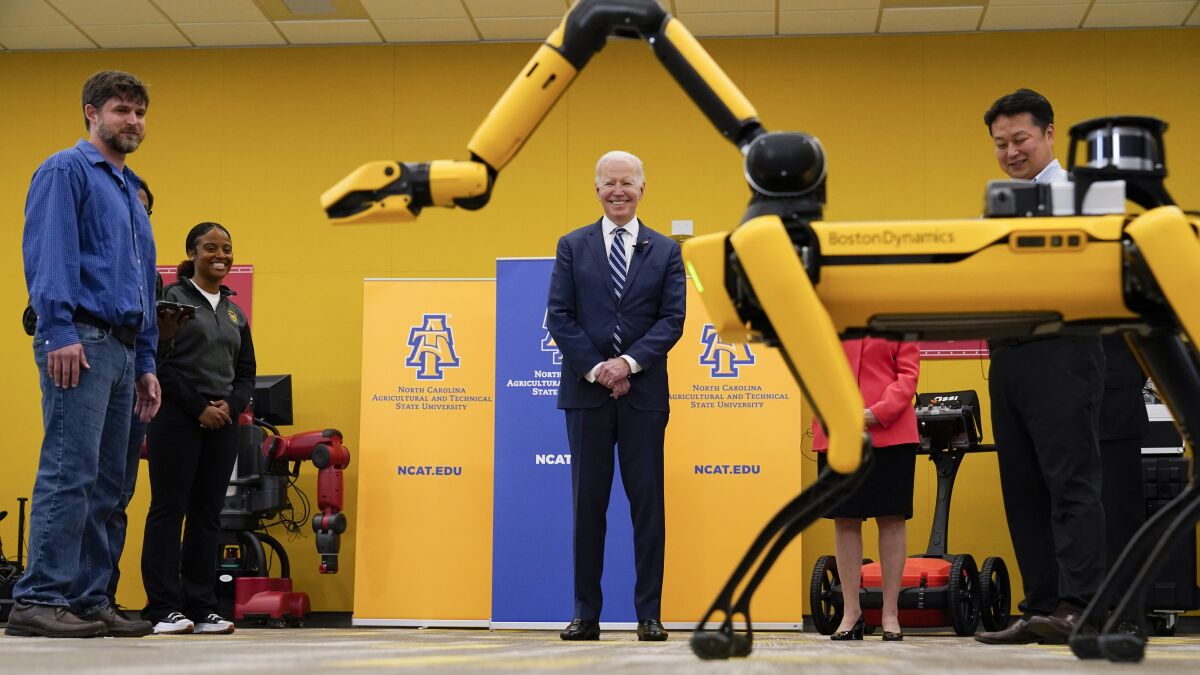President Biden looks at a robotic dog during a tour at North Carolina A&T State University