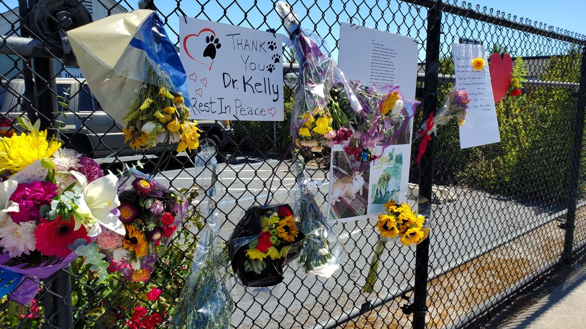 Clients left flowers, notes and pictures of pets at a memorial for veterinarian Clark Kelly.