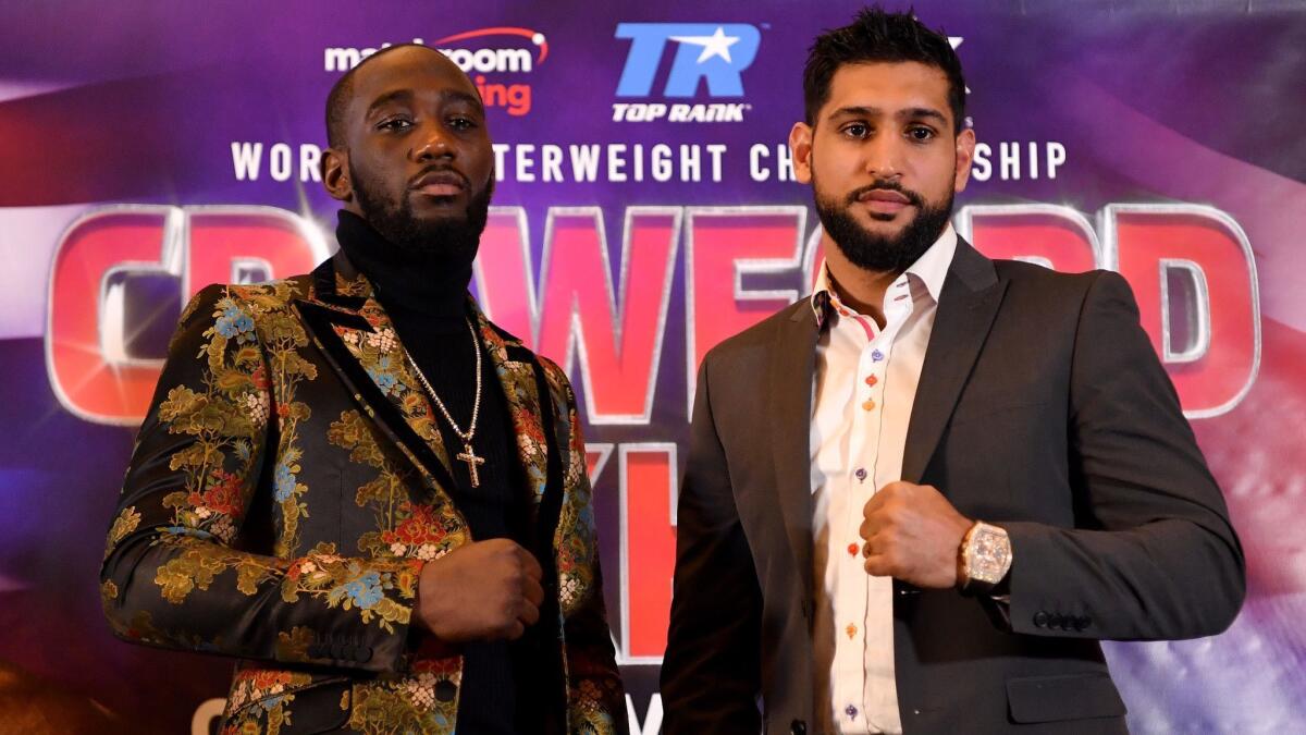 Terence Crawford, left, and Amir Khan pose during a news conference in London in January. The two boxers will meet in the ring Saturday in New York.