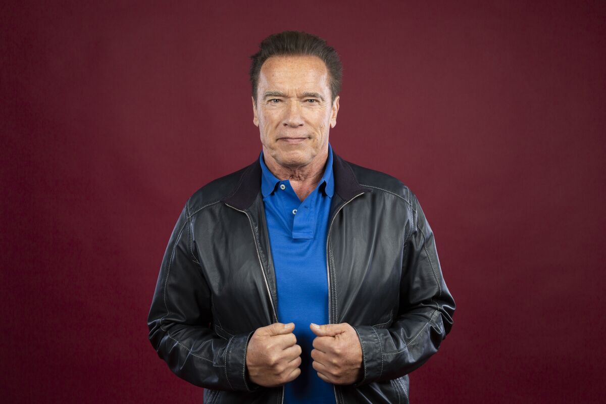A man clutching the opening of his leather jacket