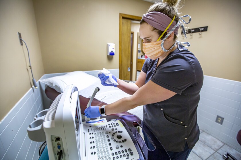 A health worker disinfects a sonogram machine.