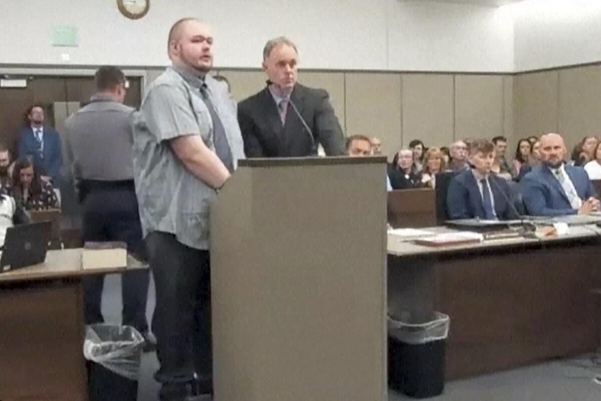 A suspect stands at a lectern in court. 