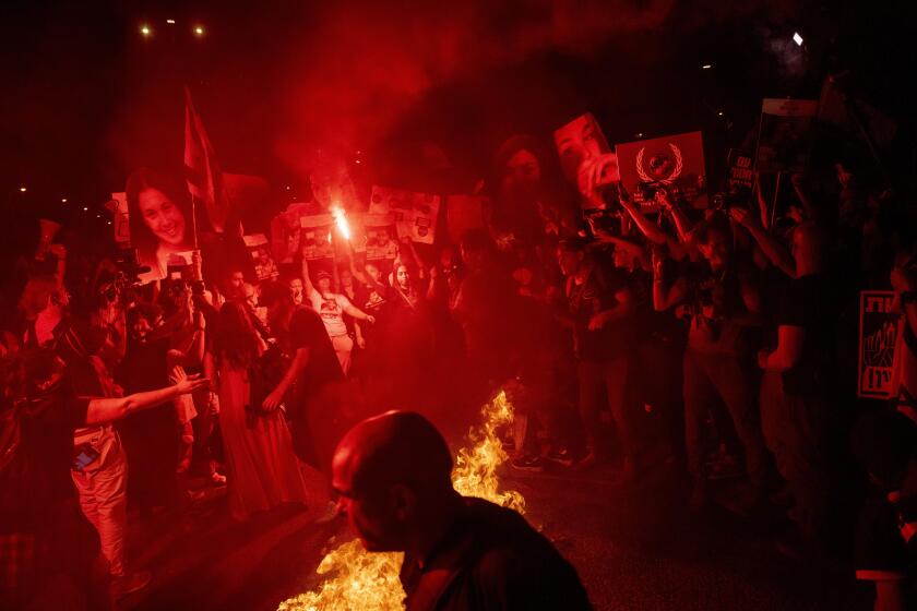 Demonstrators burn fire during a protest against Israeli Prime Minister Benjamin Netanyahu's government, and calling for the release of hostages held in the Gaza Strip by the Hamas militant group, in Tel Aviv, Israel, Sunday, May 26, 2024. (AP Photo/Ariel Schalit)