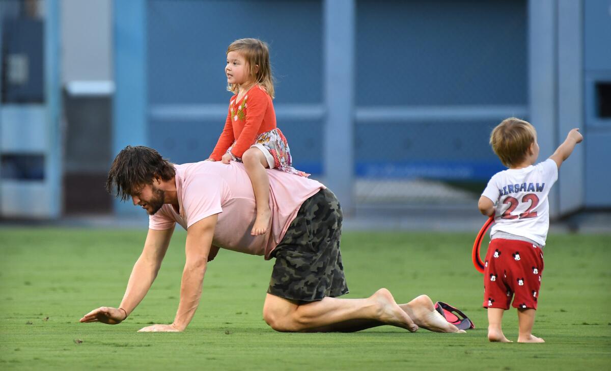 Clayton Kershaw plays with his kids after the Dodgers beat the Rockies Oct. 1, 2018.