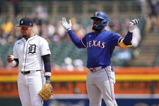 El jardinero de los Rangers de Texas Adolis García, derecha, cuestiona si su batazo era un cuadrangular, mientras que el campocorto Javier Báez (28), de los Tigres de Detroit, observa la pelota en la sexta entrada del juego de béisbol, el miércoles 17 de abril de 2024, en Detroit. A Garcia le acreditaron un doble. (AP Foto/Paul Sancya)