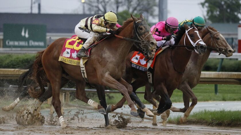 Country House, left, Maximum Security, center, and Code of Honor run side by side during the 145th Kentucky Derby on Saturday.