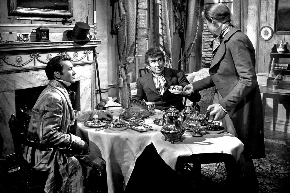 Three men around a table in a period scene from David Lean's 1946 film 'Great Expectations.'