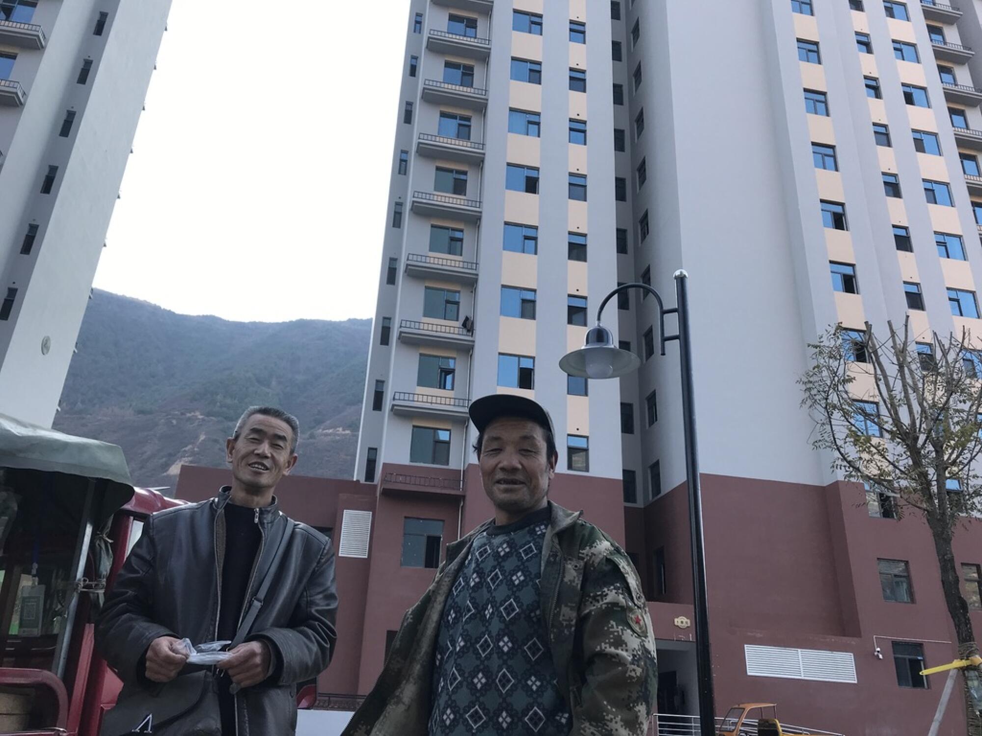 Villagers relocated from Lianghekou village stand outside the new high-rises where they now live.