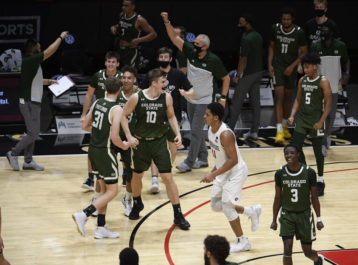 SDSU's Matt Mitchell walks off the court as Colorado State players and coaches celebrate their 70-67 win Saturday.