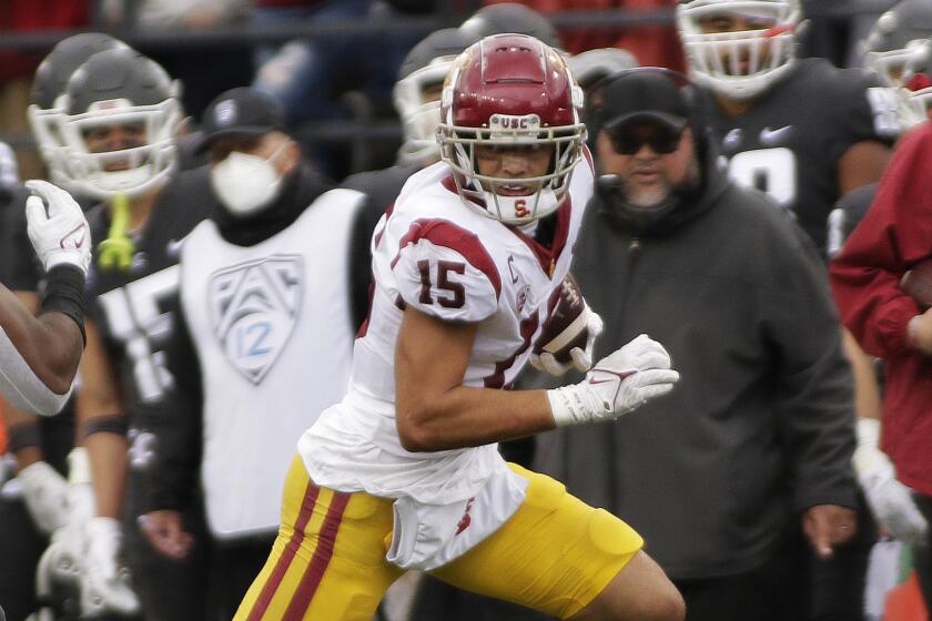 Southern California wide receiver Drake London (15) carries the ball while pursued by Washington State linebacker.