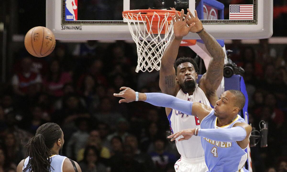 Nuggets guard Randy Foye passes around Clippers center DeAndre Jordan at the rim in the first half.