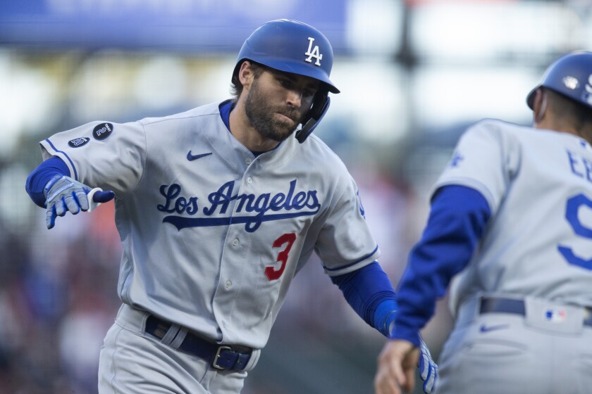 Dodgers left fielder Chris Taylor celebrates with third base coach Dino Ebel after hitting a two-run home run.