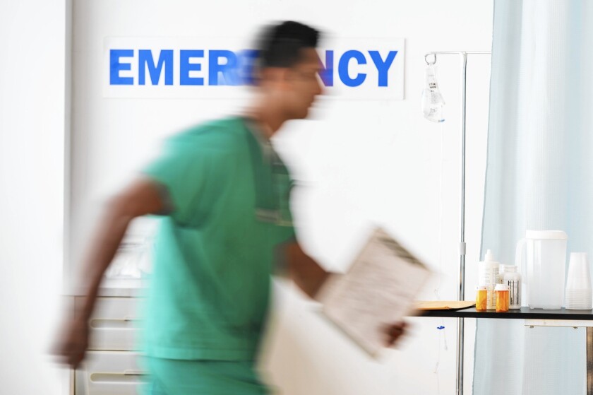 A doctor walks into a hospital emergency department.