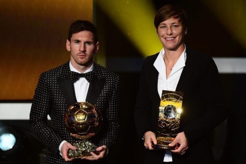 Lionel Messi and Abby Wambach accept their awards.
