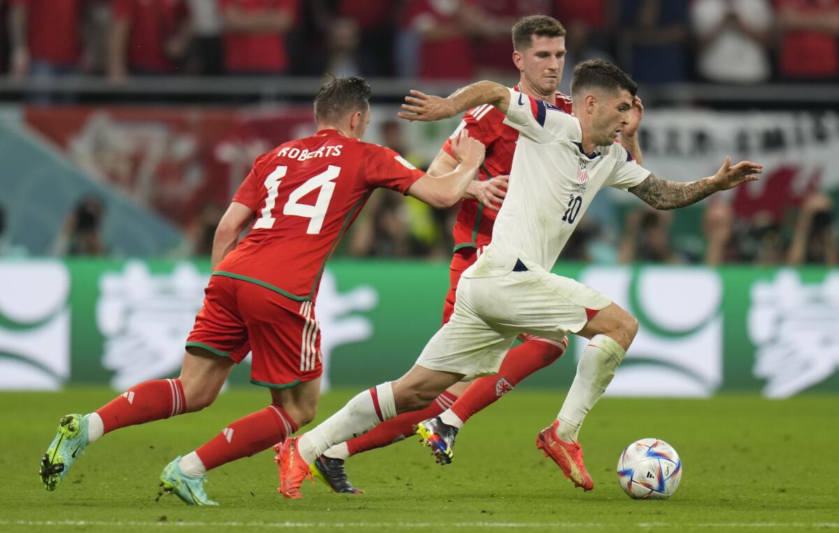 Christian Pulisic of the United States in action in front of Wales' Connor Roberts during the World Cup