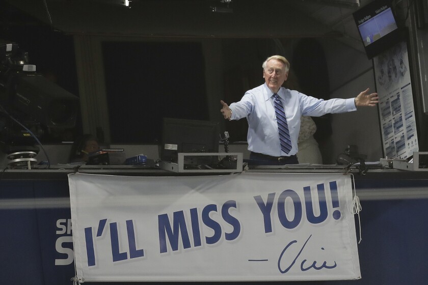 El locutor de los Dodgers de Los Ángeles, Vin Scully, gesticula en su cabina durante un juego entre Dodgers y Rockies.