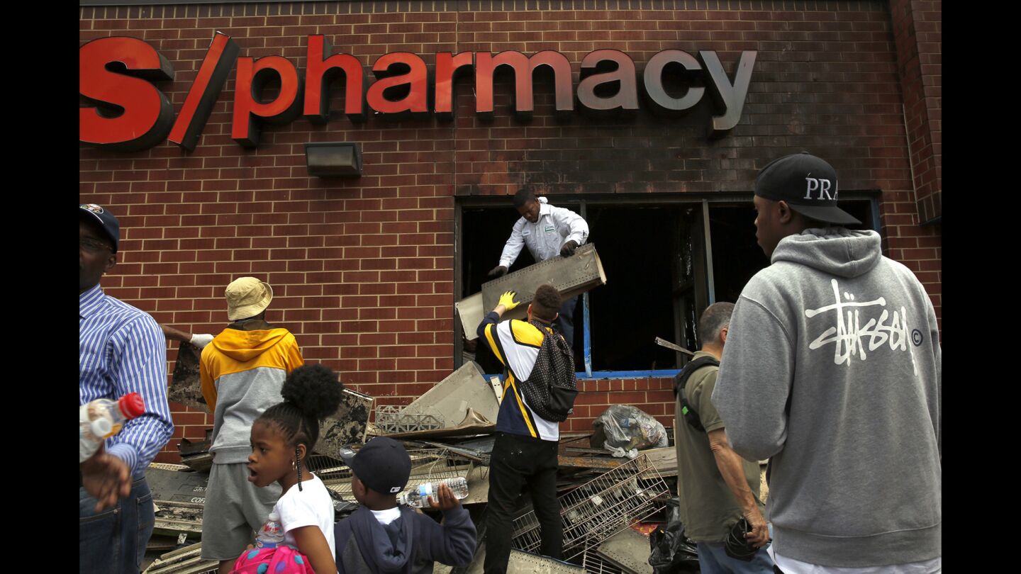 Community residents help clean up the CVS store that was looted and burned the night before in Baltimore.