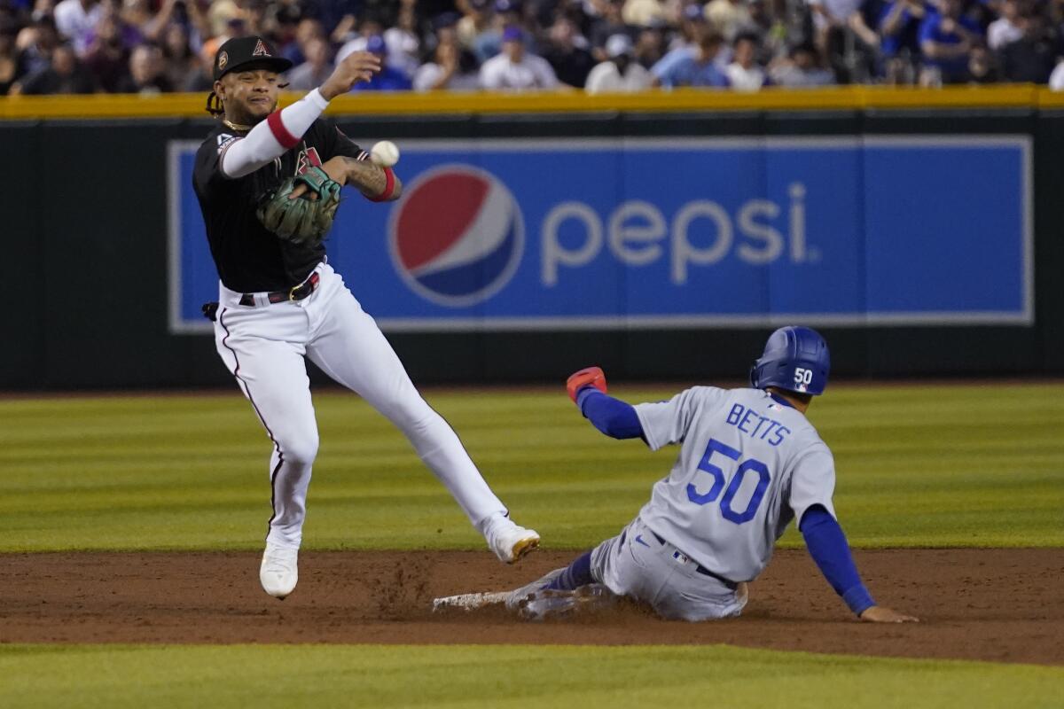 Arizona Diamondbacks' Ketel Marte forces out Dodgers' Mookie Betts as he turns a double play on Dodgers' Will Smith.