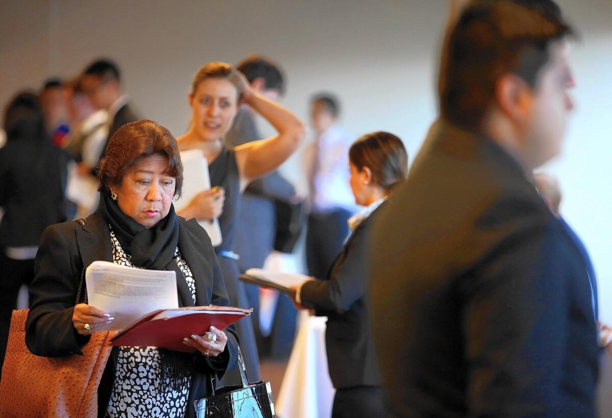 Job seekers wait in line to meet with recruiters during a HireLive career fair in San Francisco last year.