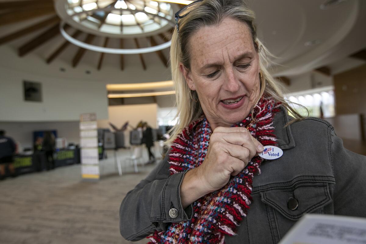 Deedee McCrory puts an "I Voted" sticker on her jacket Tuesday at Costa Mesa's Norma Hertzog Community Center.