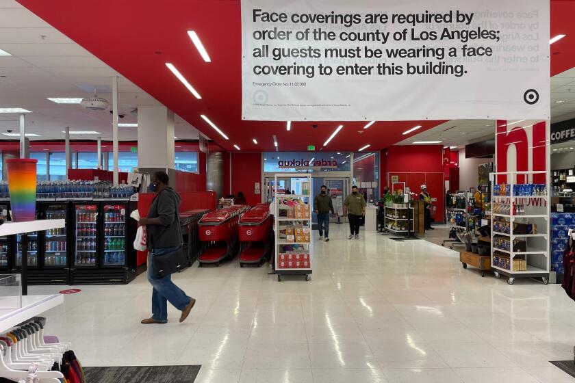LOS ANGELES, CA - MAY 17: Signage inside Target reads that there is a mask mandate on the first day it has dropped the requirement for fully vaccinated customers, joining with Walmart, Trader Joes, Starbucks, Costco and other businesses in downtown on Monday, May 17, 2021 in Los Angeles, CA. (Dania Maxwell / Los Angeles Times)