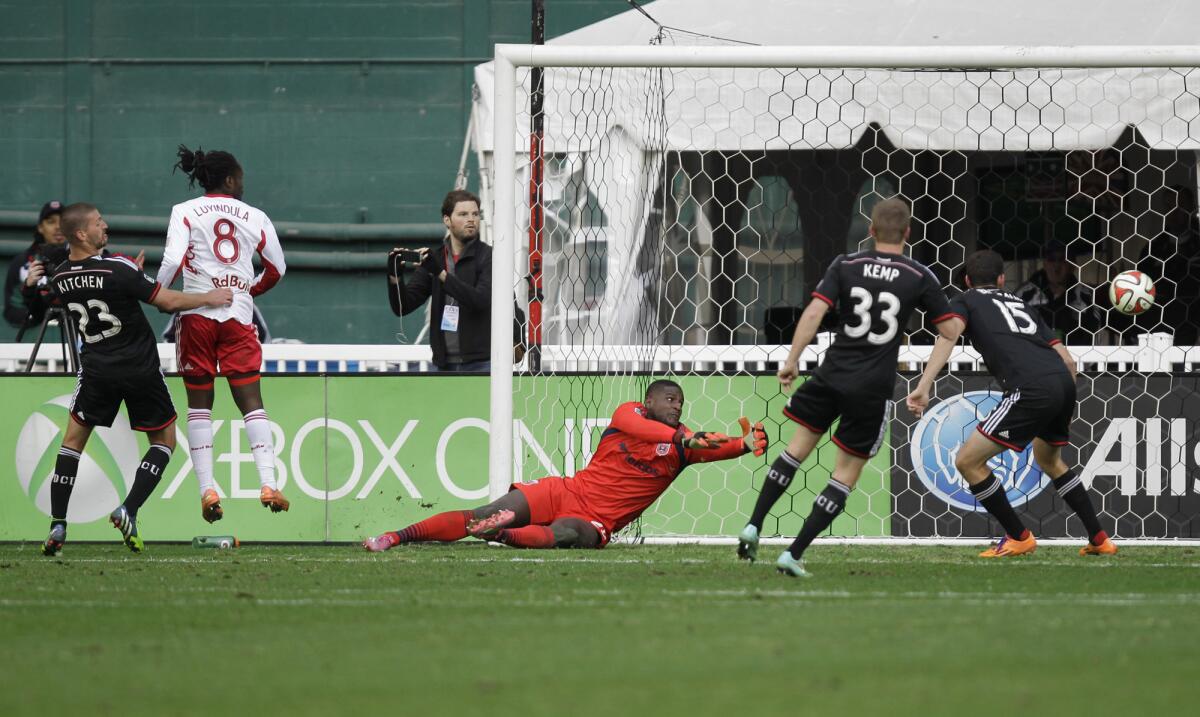 New York Red Bulls' Peguy Luyindula (8) scores against DC United goalkeeper Bill Hamid Saturday during the second match of an MLS playoff series.