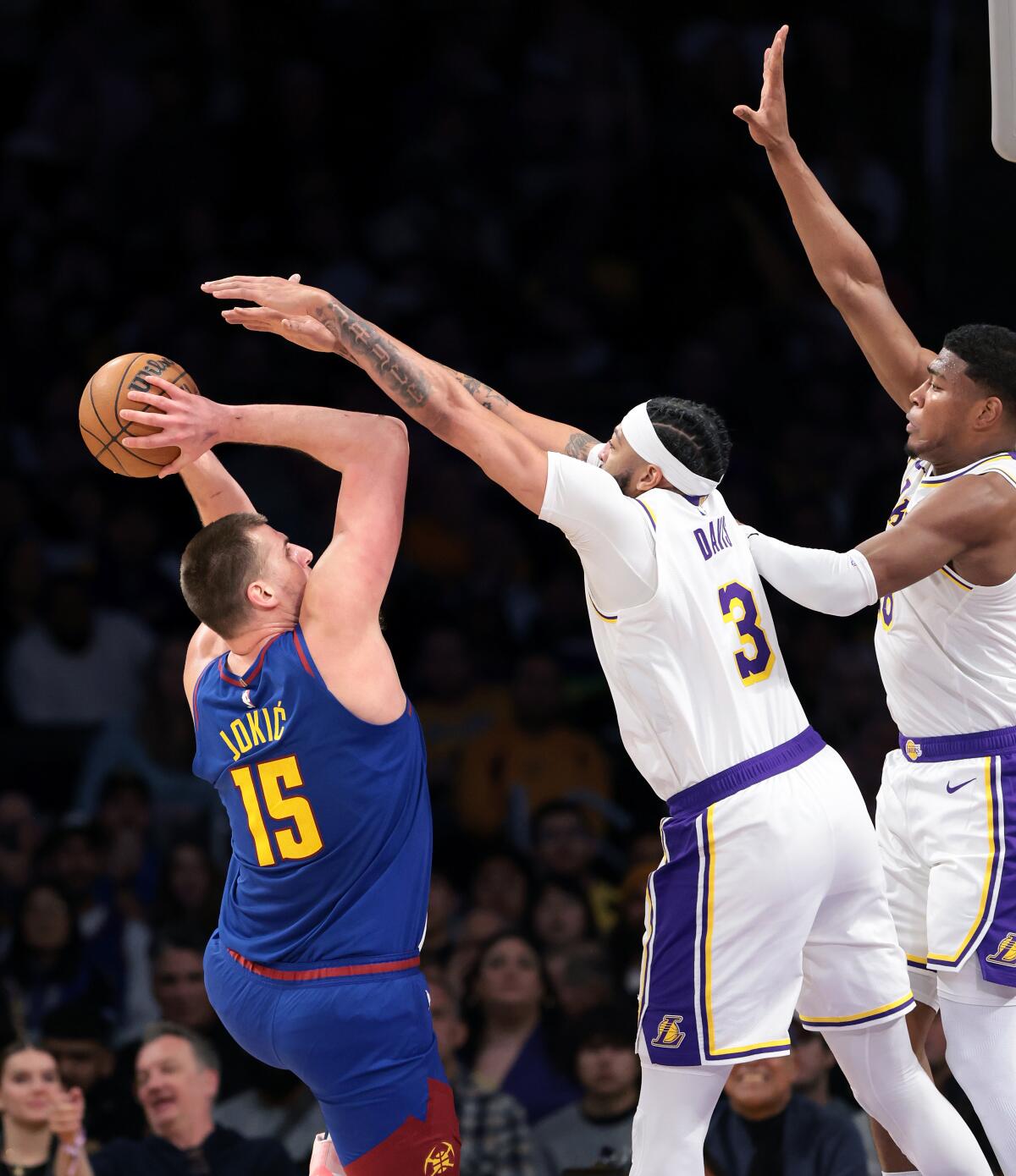 Nuggets'ın pivotu Nikola Jokic, Lakers'ın forveti Anthony Davis, pivot ve Rui Hachimura'nın üzerinden şutunu çekiyor.