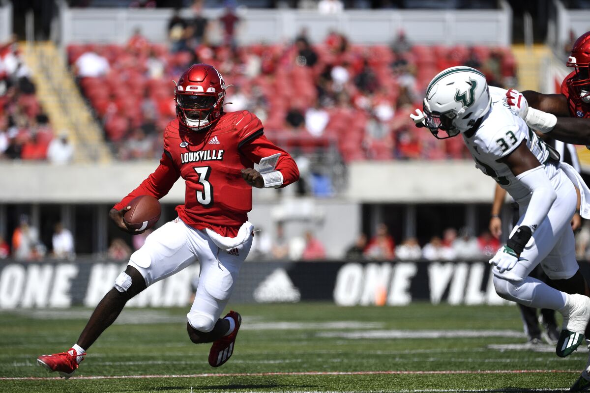Louisville quarterback Malik Cunningham (3) is pursued by South Florida cornerback Timarcus Simpson (33) during the second half of an NCAA college football game in Louisville, Ky., Saturday, Sept. 24, 2022. Louisville won 41-3. (AP Photo/Timothy D. Easley)