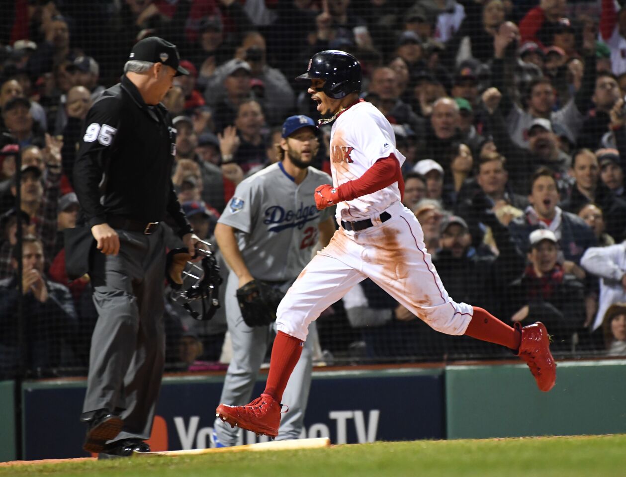 As Dodgers pitcher Clayton Kershaw watches, Red Sox's Mookie Betts scores the first run in the first inning of game one.