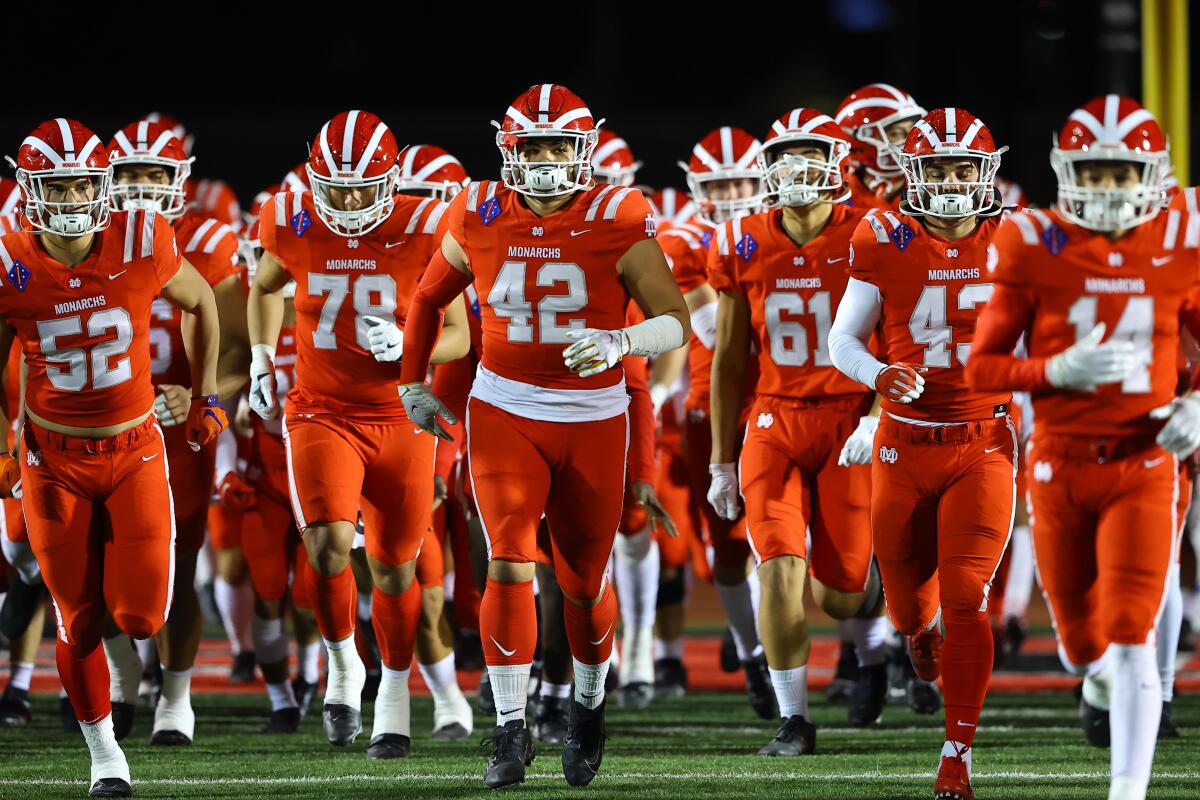 Mater Dei football players take the field.