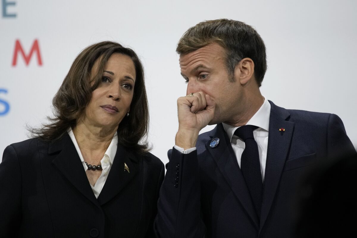 France's President Emmanuel Macron, right, talks with U.S Vice President Kamala Harris, during the Paris Peace Forum, in Paris, Thursday, Nov. 11, 2021. Some world leaders and internet giants are expected to issue a global call to better protect children online during a Paris summit of about 30 heads of state and government, including U.S. Vice-President Kamala Harris. (AP Photo/Christophe Ena)
