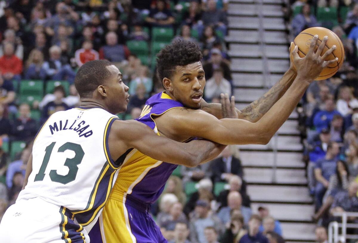 Lakers guard Nick Young is defended by Utah Jazz guard Elijah Millsap during a game on Jan. 16.