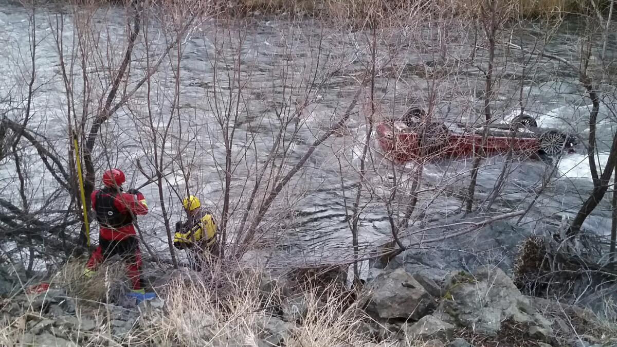 The Siskiyou County sheriff's dive team works to rescue a man trapped in his upside-down car in a frigid river near Yreka, Calif.