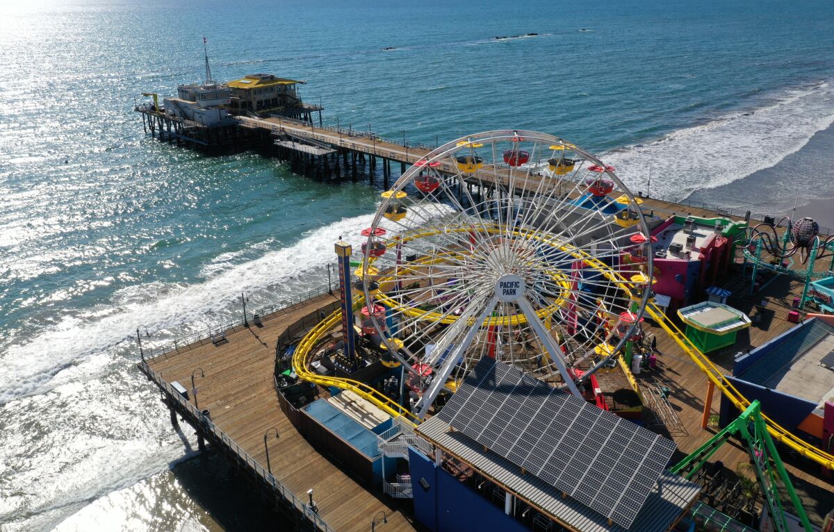 An aerial view of closed Santa Monica Pier earlier this year shows the Ferris wheel and ocean beyond.