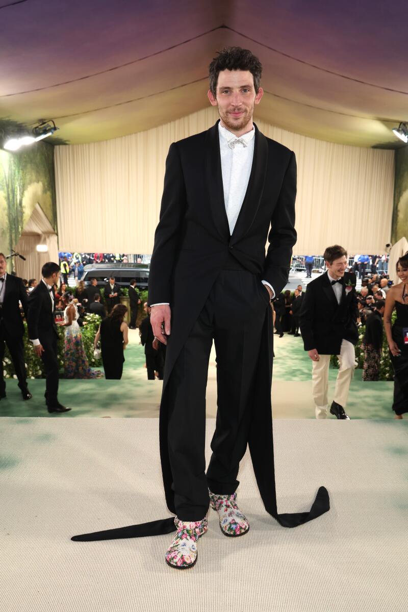 If you love visual puns, you’ll love how “Challengers” star Josh O’Connor wears a tailcoat with extended “tails” that drag the carpet. His low-heel, floral booties are likely the envy of every woman in heels.