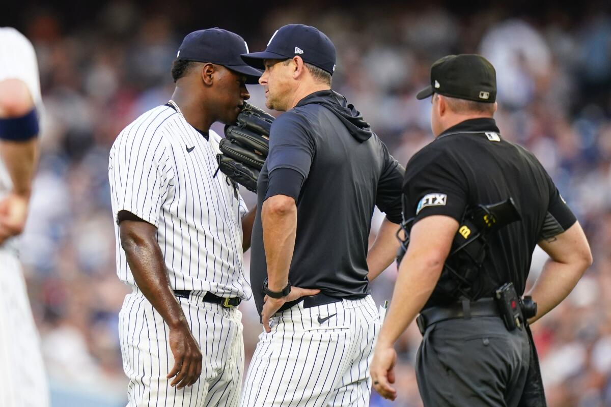 New York Yankees starting pitcher Luis Severino, left, talks to manager Aaron Boone during the second inning of the team's baseball game against the Cincinnati Reds on Wednesday, July 13, 2022, in New York. (AP Photo/Frank Franklin II)